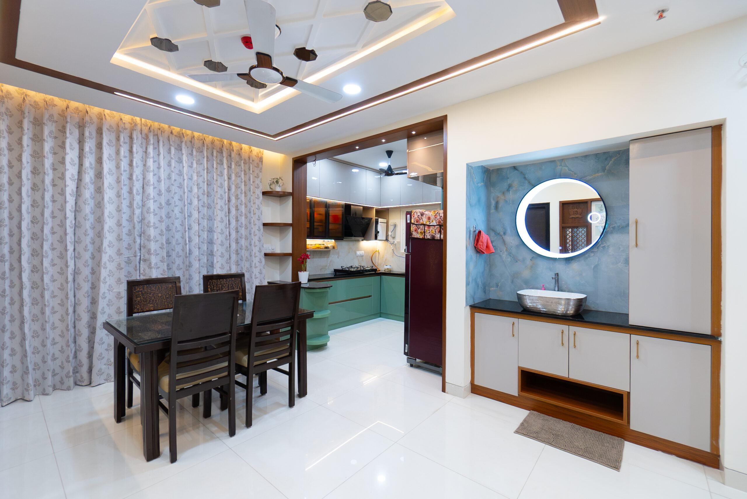 Modern dining and kitchen space designed by interior designers in Hyderabad offering premium interior services with elegant ceiling, modular kitchen, and stylish wash area.